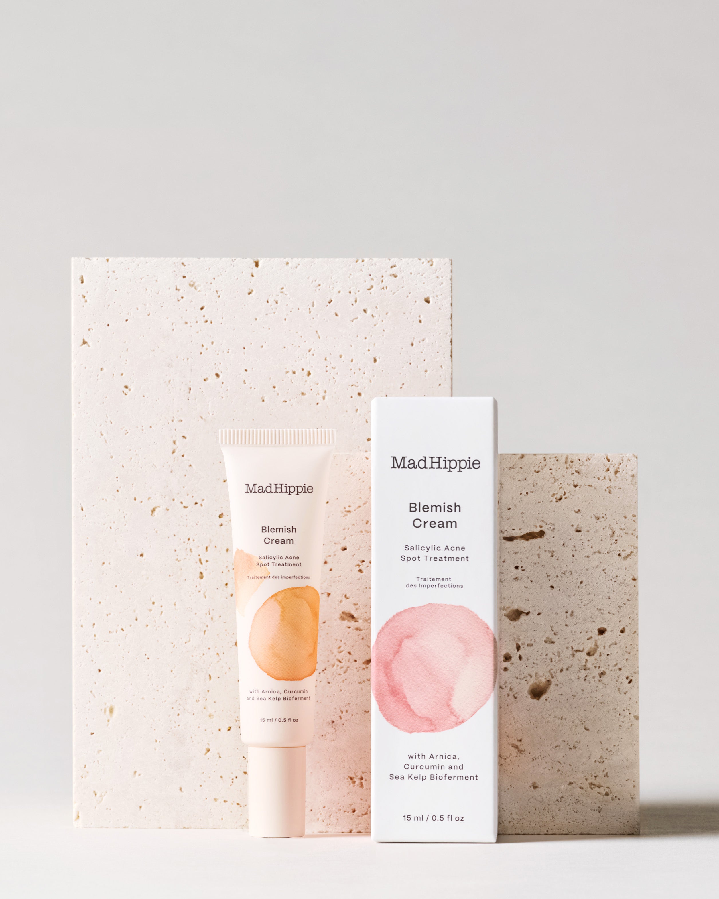 Blemish Cream tube + box in front of stone slabs, with gray background
