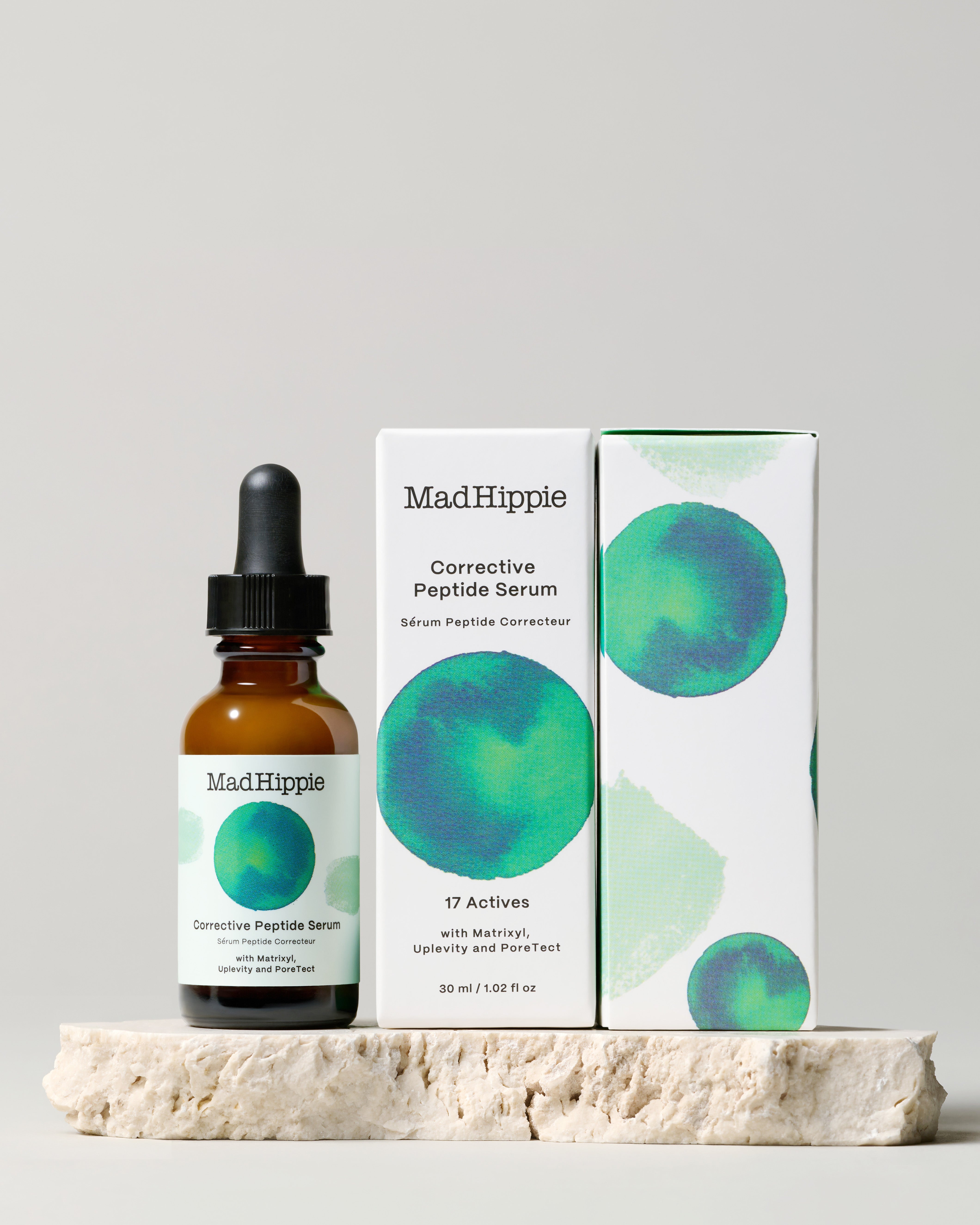 Corrective Peptide Serum + two boxes on stone slab, with gray background