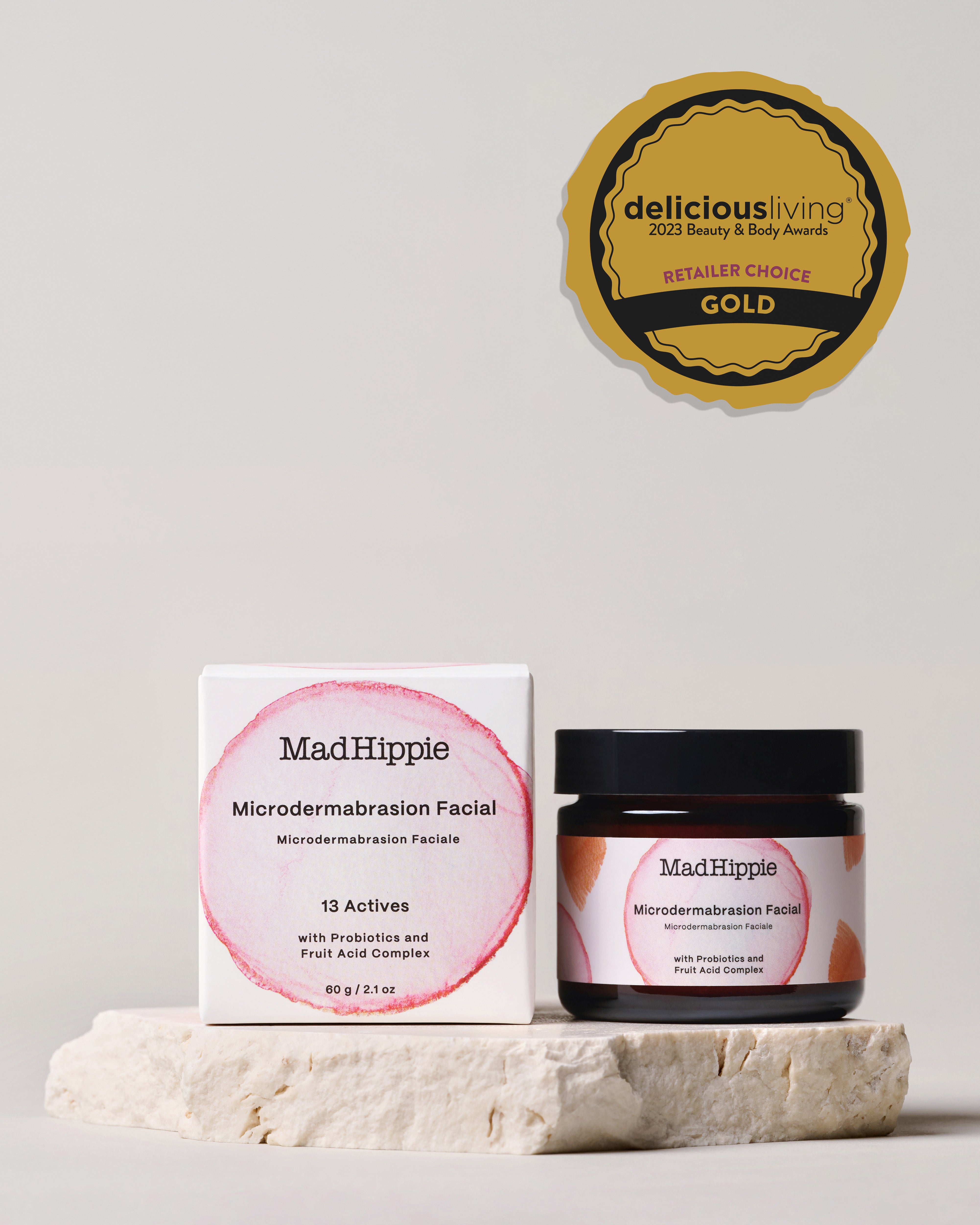 Microdermabrasion Facial Jar + box on stone slab, with gray background. Gold award badge in upper right corner